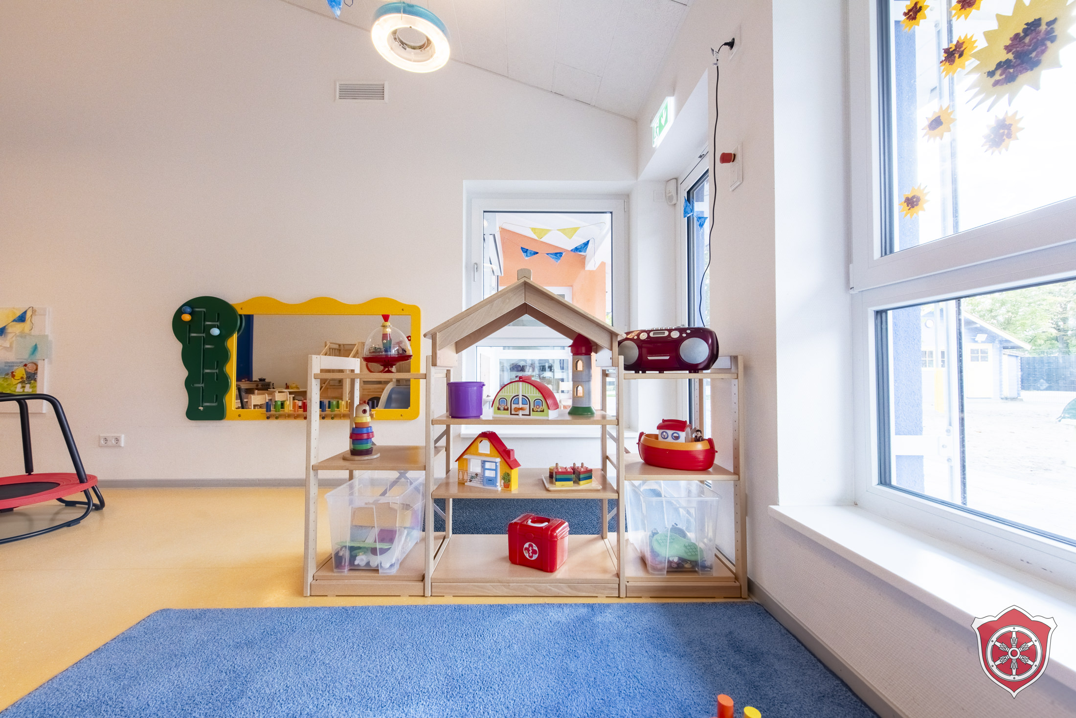 Bild zeigt Gruppenraum mit Regal in dem Kinderspielsachen liegen