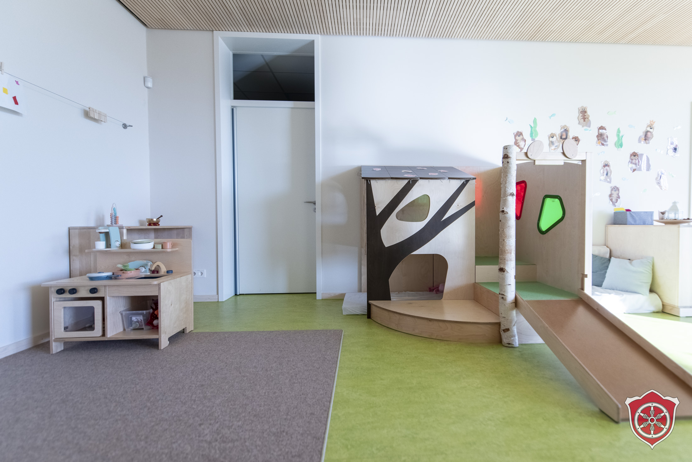 Der U3 Gruppenraum zeigt eine kleine Spielküche und eine Hochebene.