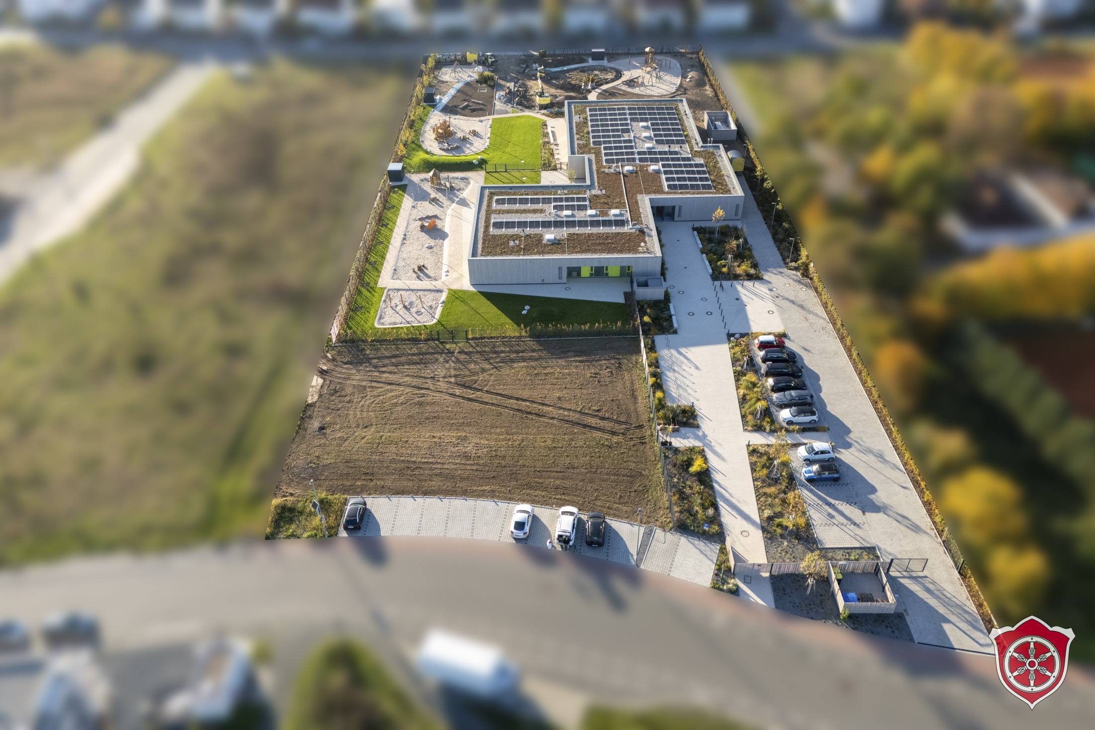 Das Bild zeigt das komplette Gebäude mit Außengelände aus der Vogelperspektive.