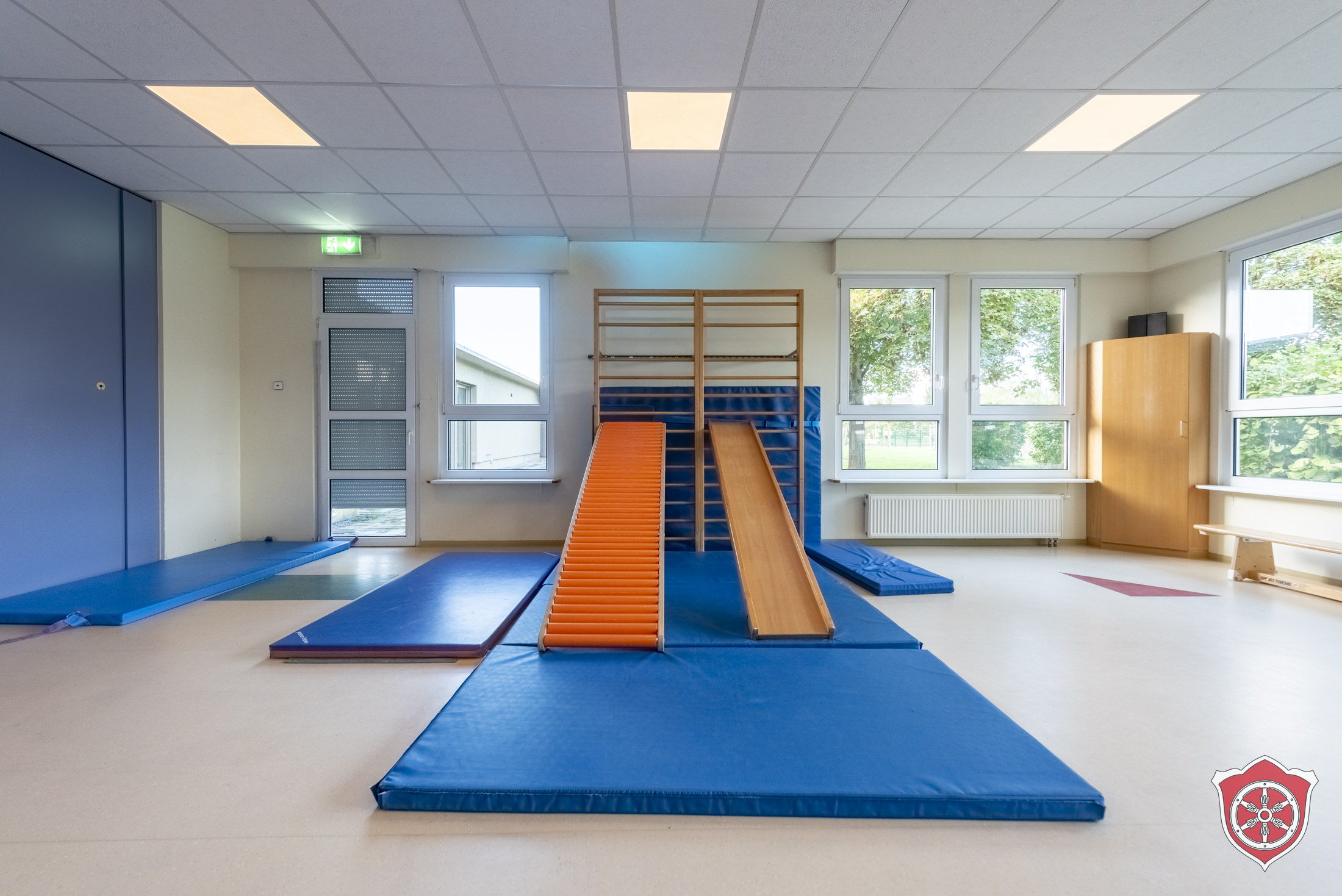 Turnraum ist mit Matten ausgelegt. AN der Sprossenwand sind zei Rutschen befestigt