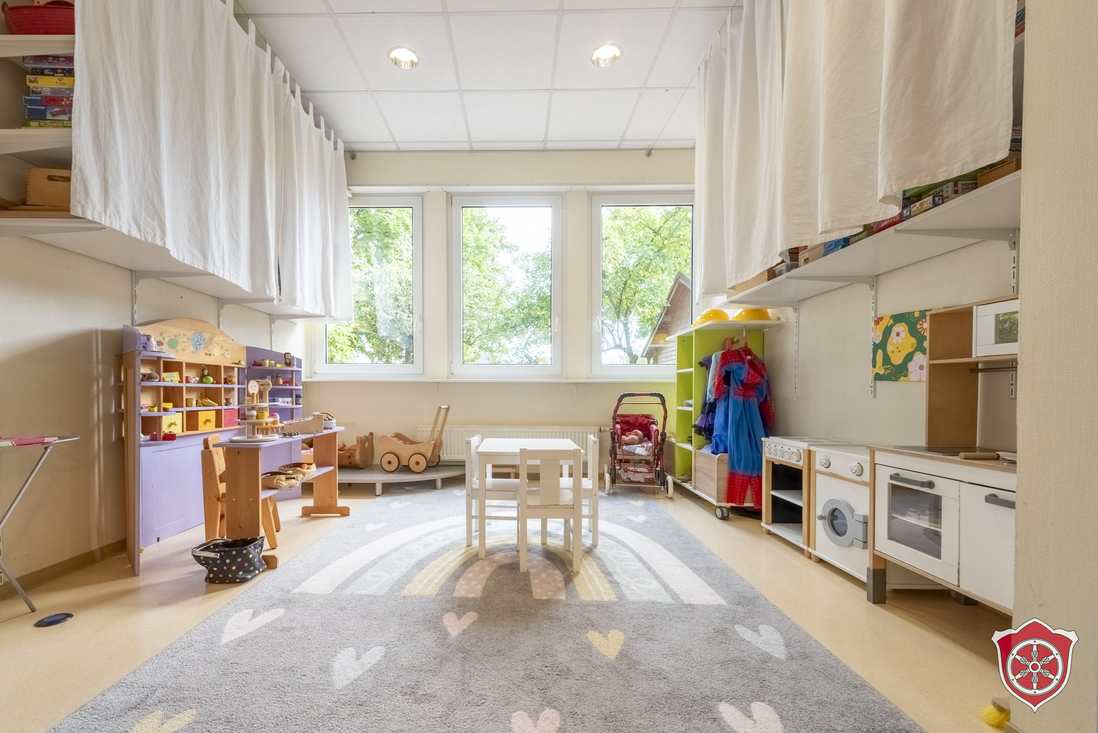 Der Funktinsraum "Rollenspiel" ist zu sehen mit einer Spielküche, Tisch mit Stühlen und einem Kaufmannsladen.