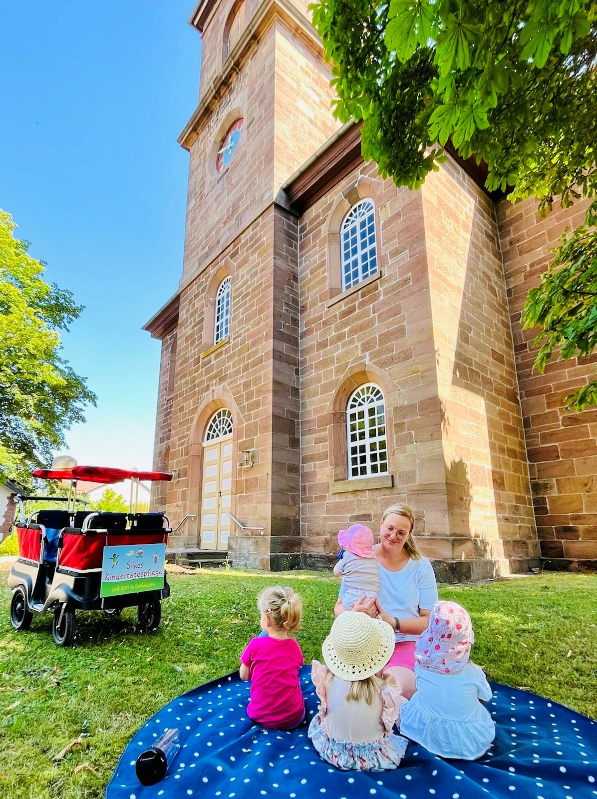 Bild Silke Dörrbecker mit Kindern vor Kirche